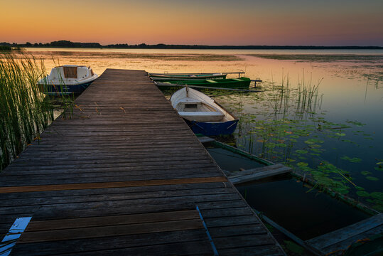 sunset on the lake and boat in wytyckie lake, poland lubelskie