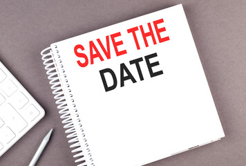 SAVE THE DATE text on notebook with calculator and pen,business