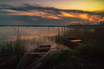 Obraz premium sunset on the lake and boat in wytyckie lake, poland lubelskie