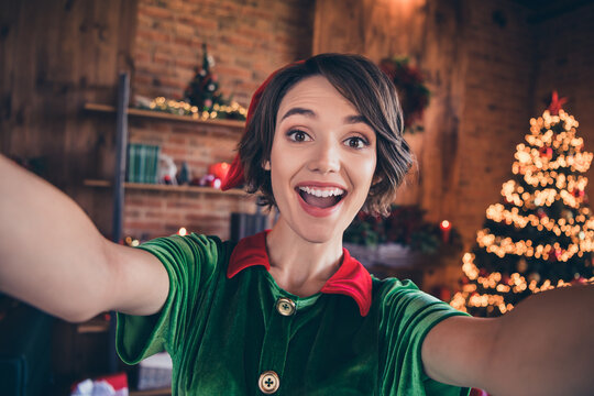 Photo of young cheerful shocked woman elf hold hands camera make selfie xmas holiday indoors inside house home