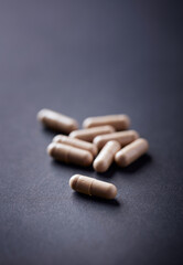 Cat's Claw (Uncaria tomentosa)  Extract Capsules. A Dietary Supplement. Immune System Support. Dark paper background. Close up. Copy space. 