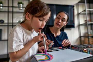 Cute small girl child draw with markers in album