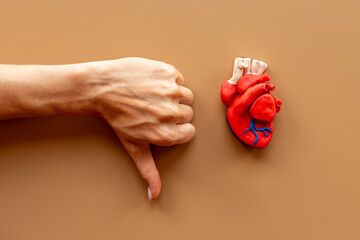 Heart health concept with hands and human heart model