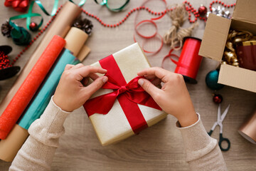 Close up of hands tying a bow on a gift - Powered by Adobe