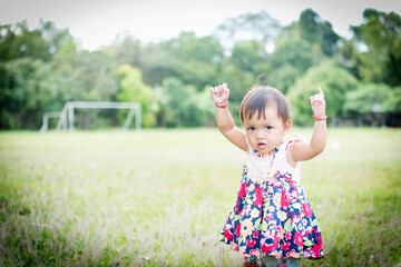 Close up little girl Asian happiness running on lawn, 1-2 year old.