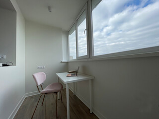 Cozy home office workspace near big window overlooking blue sky with clouds, copy space