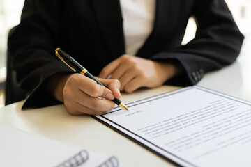 Close-up business woman writing contract signing agreement.