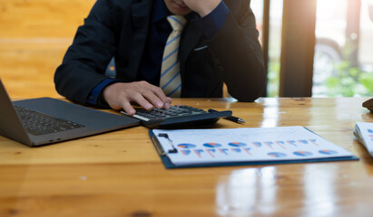 Businessman calculates calculator and is serious about analyzing business reports. Accounting...