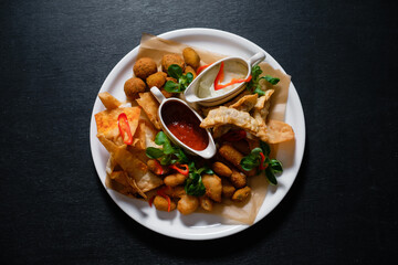 Beer snacks with nacho, grilled cheese, meat, sauce and potatoes.