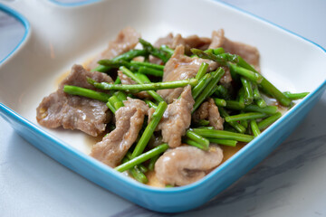 Asparagus sauteed with pork in a white ceramic dish