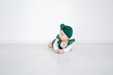 Little cute baby girl posing. A fashionable baby is photographed for advertising in green clothes