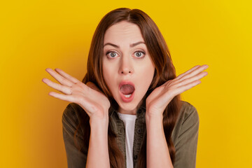 Portrait of crazy girlish excited lady hold palms open mouth on yellow background