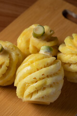 Small Phulae pineapple on a wooden chopping board