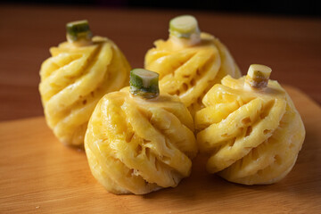 Small Phulae pineapple on a wooden chopping board