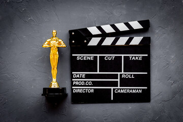 Movie clapper board with golden film award statue