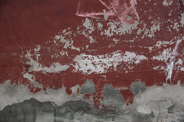 a fragment of a plastered brick wall with layers of old paint and cement