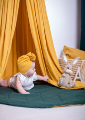 cute baby girl posing. A fashionable Baby is photographed for advertising.Fashionable baby in a yellow turban