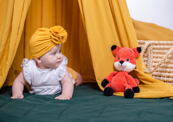 cute baby girl posing. A fashionable Baby is photographed for advertising.Fashionable baby in a yellow turban