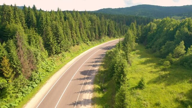 The drone follows a cyclist riding on a mountain road. Filmed in 4k, drone video.