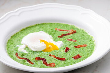 creamy spinach soup with poached egg and bacon