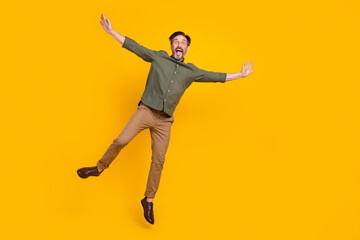 Fototapeta na wymiar Full length body size view of attractive cheerful funny man jumping having fun isolated over bright yellow color background