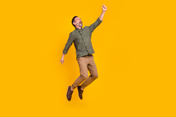 Full length body size view of attractive cheerful man jumping hanging isolated over bright yellow color background