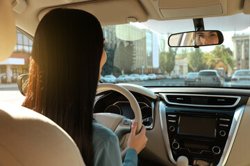 Beautiful young driver sitting in modern car
