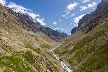 A river stream flowing through the deep gorge of the mountains of a remote Himalayan valley on a trekking route in the Zanskar region in India.