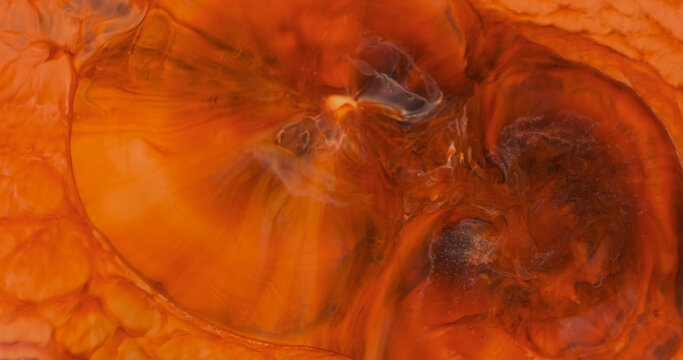 Red paint abstract explosion background, close-up. Red-orange acrylic paint flower blooms in splashes. Intense splash of bloody ink. Abstract painted motion texture. Macro pigment flowing