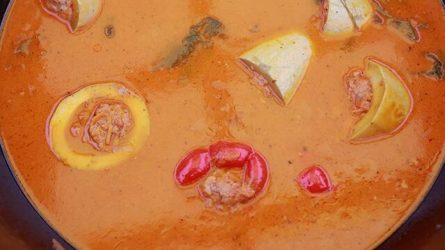 People hands are preparing food. Peppers, tomatoes, zucchini and grape leaves stuffed with minced meat.