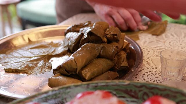People cook dolma food.
Grape leaves stuffed with minced meat.