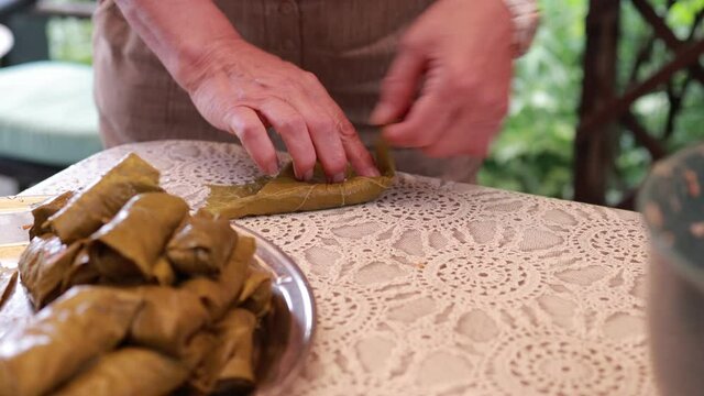 People cook dolma food.
Grape leaves stuffed with minced meat.
