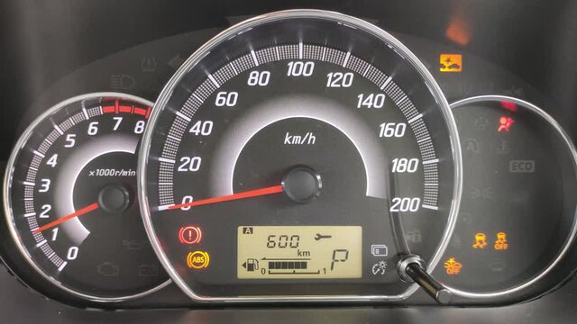 Close-up of the engine, the speedometer, and the fuel level in the car. The concept of low-cost oil. Fill up the tank as soon as possible.