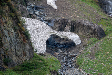 a snow bridge from the snow at the last winter in the alps in the hohe tauern national park in austria