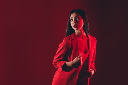 Portrait of gorgeous chic brunette girl posing night club event isolated over bright red light shine color background