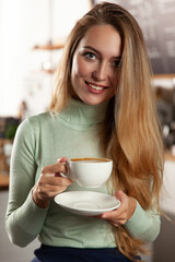 Beautiful girl in a cafe drinks coffee.