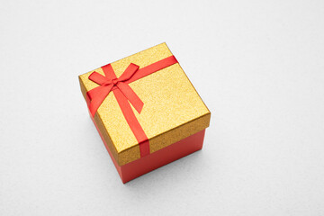 Gold gift box with a ribbon on a light background. Top view. 