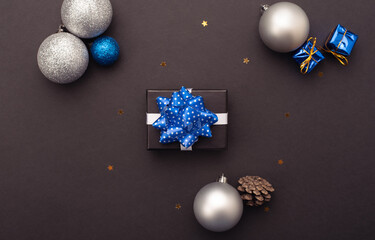 Little gift box, cones and Christmas balls on a dark background with stars