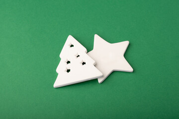 White star and Christmas tree made of ceramics on a deep green background. 
