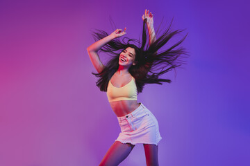 Portrait of attractive cheerful carefree girl dancing clubbing isolated over vivid violet purple...