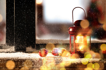 Red lantern with candle and bells near window outdoors. Christmas eve © New Africa