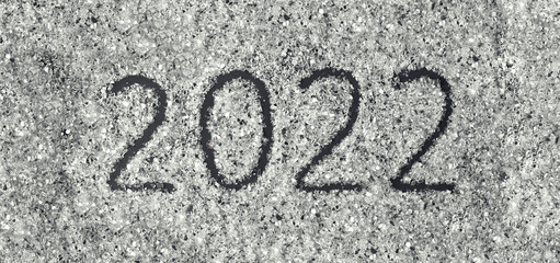 Number 2022 written on a scattered glitter. Flat lay, top view.