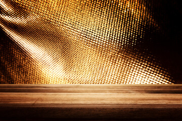 Empty table in front of black and gold textured background. For product display montage