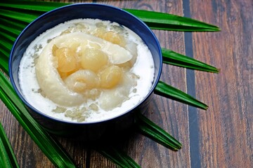 Sweet sticky rice with longan and coconut sliced in coconut milk (Kao niao piak lumyai). Authentic Thai dessert.