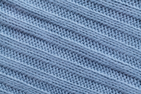 Close up of blue textile texture. Woolen knitted fabric background. Detailed warm woolen jacket.