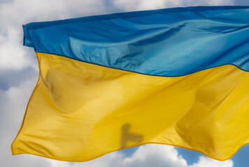 Ukraine flag waving on the wind against the blue sky