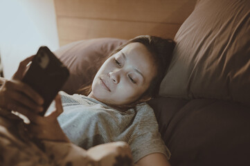 Young women in moody emotion when her checking smart phone in bedroom