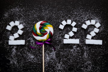 Numbers 2022 from doughnut and sugar. Conceptual photography. Diet. Banner. Business. New Year. Black background.