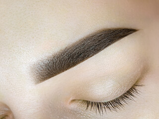 eyebrow tattoo, completed work of permanent eyebrow makeup close-up of a closed eye. - obrazy, fototapety, plakaty