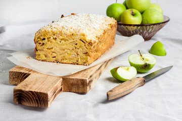 Apple and coconut loaf cake on wooden cutting board